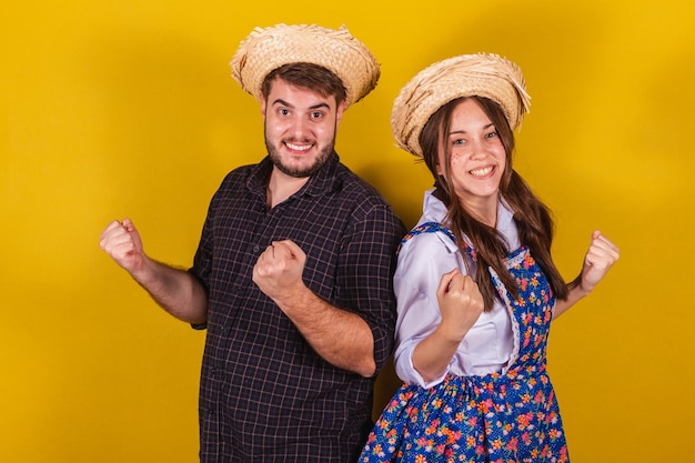 Mooi paar dat typische kleding draagt voor de Festa Junina Juichende overwinning vieren