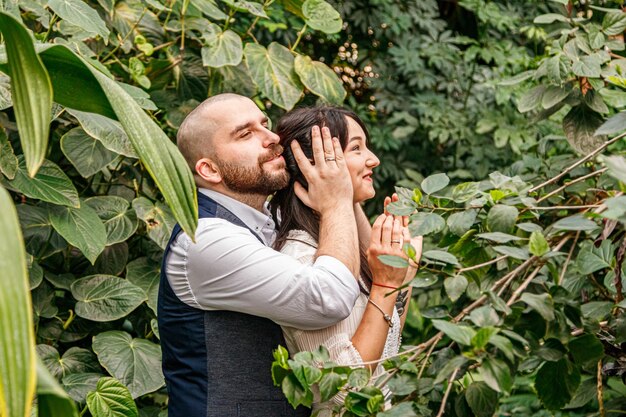 Mooi paar meisje en jongen in het park tussen tropische bomen