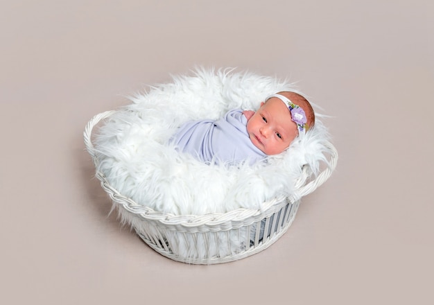 Mooi pasgeboren babymeisje verpakt in een paarse cocon