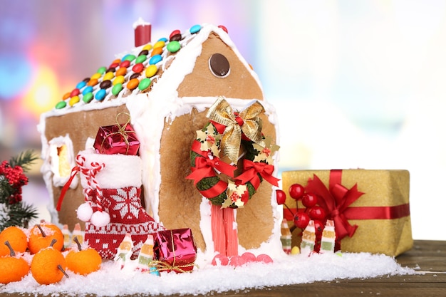 Mooi peperkoekhuis met kerstdecor op houten tafel