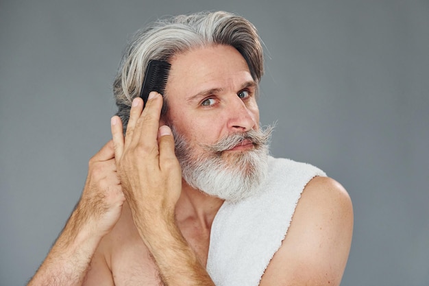 Mooi portret Stijlvolle moderne senior man met grijs haar en baard is binnenshuis