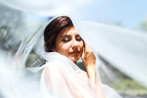 mooi portret van de bruid onder een sluier elegante vrouw met professionele make-up en kapsel