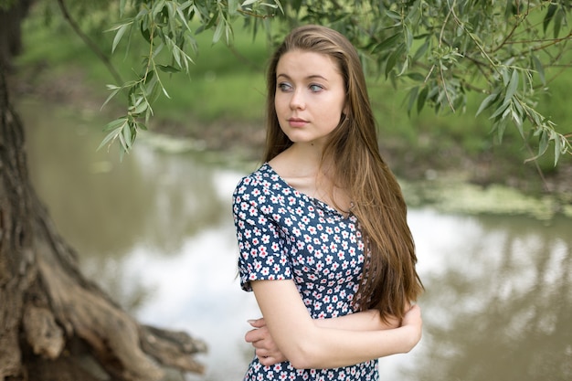 Mooi portret van een blond meisje met groene ogen in het late voorjaar in het park.