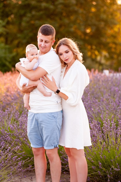 Mooi portret van een jong gezin met baby in lavendelveld. Familie liefde en waarde concept.