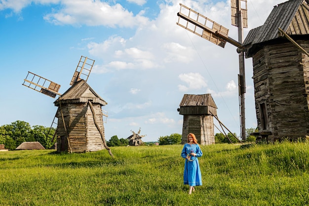 Mooi roodharig meisje in een blauwe jurk Oekraïens met een krans op haar hoofd