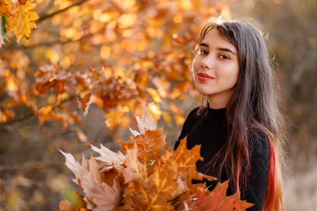 mooi roodharig meisje met een boeket gele herfstbladeren