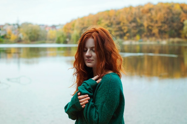 mooi roodharig meisje met sproeten, blauwe ogen in het herfstpark. Herfst stijl. trui, warme trui