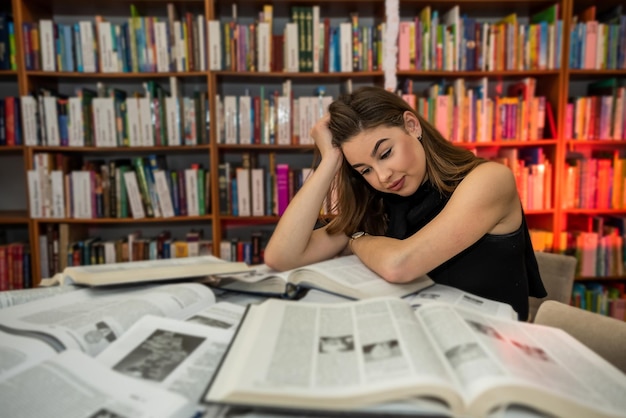 Mooi schattig jong meisje leest en studeert in de plaatselijke bibliotheek