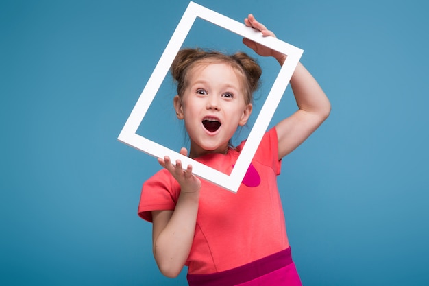 Mooi schattig klein meisje in roze jurk houdt afbeeldingsframe