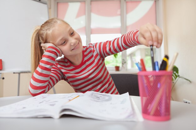 Foto mooi schoolmeisje genieten van tekenen