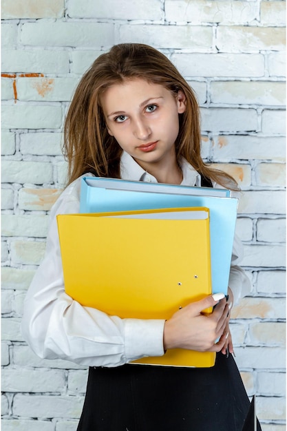 Mooi schoolmeisje in een uniform dat naar de camera kijkt