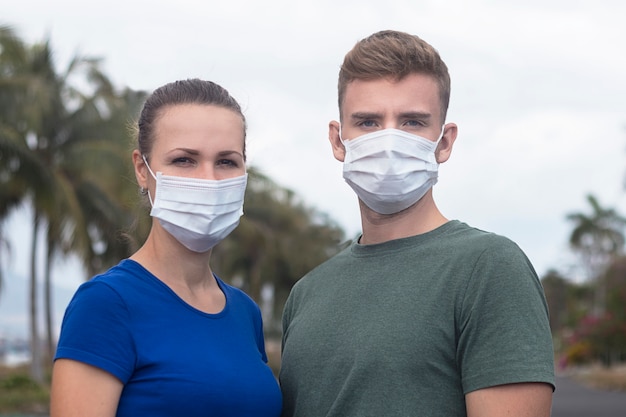 Mooi seriuspaar, kerel, meisje in beschermend steriel medisch masker op gezicht in openlucht bij Aziatische straat. Luchtvervuiling, virus, nieuw Chinees pandemisch coronavirusconcept. Man en vrouw.
