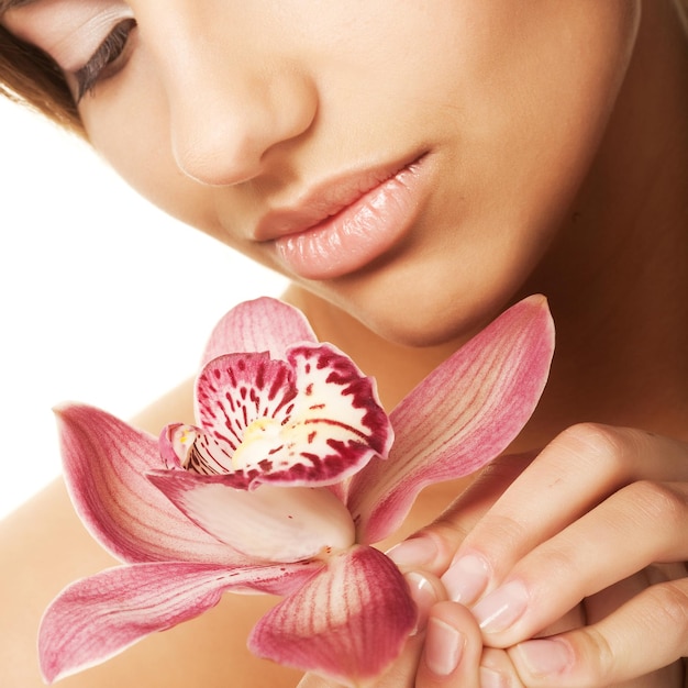 Mooi spa meisje met orchidee bloem in haar handen