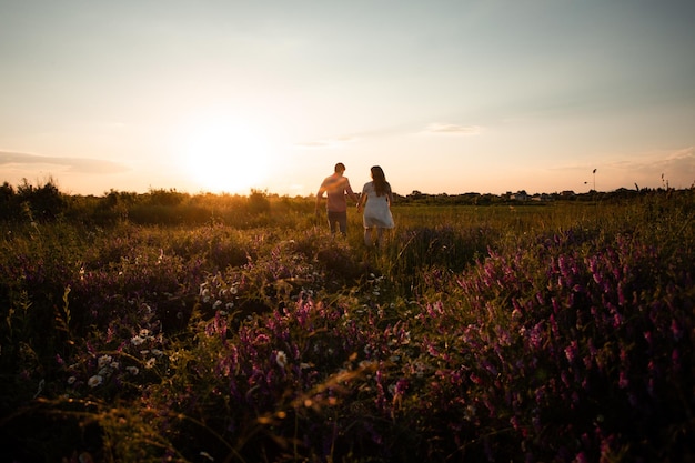 Foto mooi stel dat in het zomerveld loopt