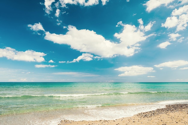 Mooi strand en blauwe lucht met wolken. Vintage filter, retro-effect