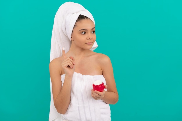 Mooi tienermeisje in badtoren die lichaamscosmetisch gezichtsmasker toepast