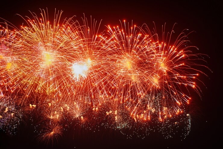 Mooi vuurwerk bij nacht. Gekleurde burst op zwarte lucht. Lichtspoor met heldere uitbarsting en vonken van vuurwerk dat opwaait in de donkere nachtelijke hemel. Lange blootstelling