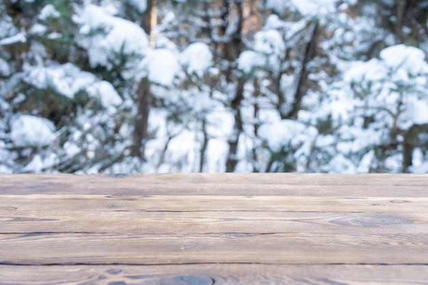 Mooi winters tafereel. onscherpe achtergrond van besneeuwde kerst natuur achtergrond, houten tafelblad op glanzende bokeh. Voor productweergave Kersttijd mock-up