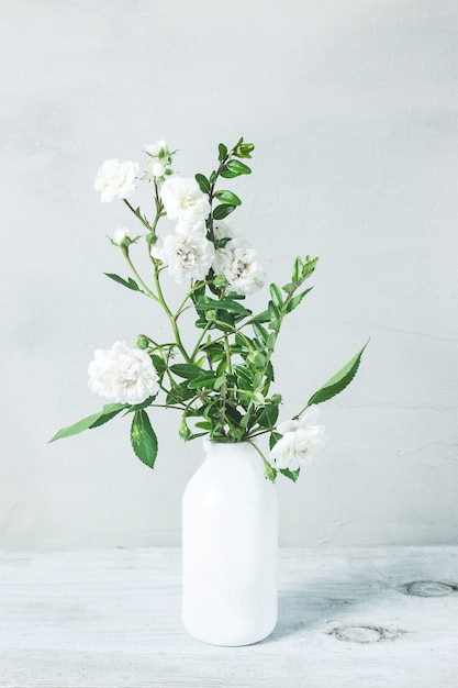 Mooi wit roze bloemenboeket in witte vaas op grijze lijst
