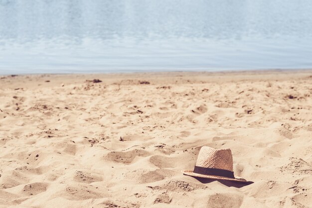 Mooi zandstrand en strohoed. zomer en reizen concept.