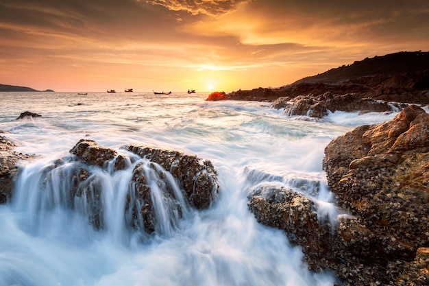 Foto mooi zeegezicht met zee en rock op zonsondergang achtergrond