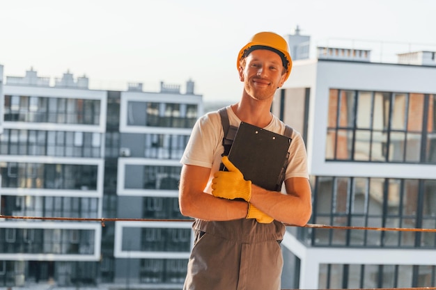 Mooie achtergrond Jonge man aan het werk in uniform bij de bouw overdag