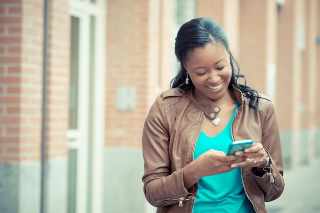 mooie Afrikaanse jonge vrouw met behulp van smartphone