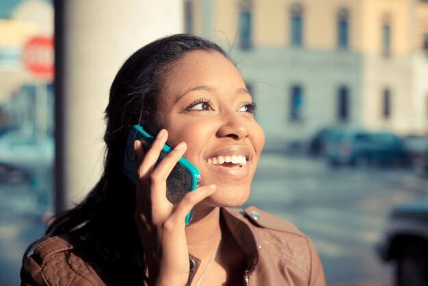 Foto mooie afrikaanse jonge vrouw met behulp van smartphone