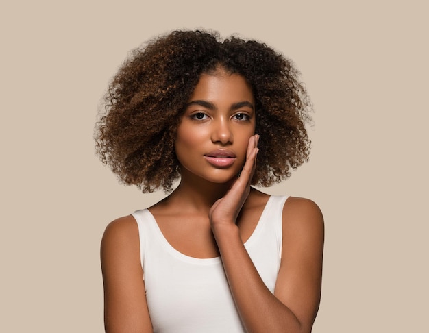 Mooie Afrikaanse vrouw wit t-shirt portret afro kapsel wat betreft haar gezicht Kleur achtergrond bruin