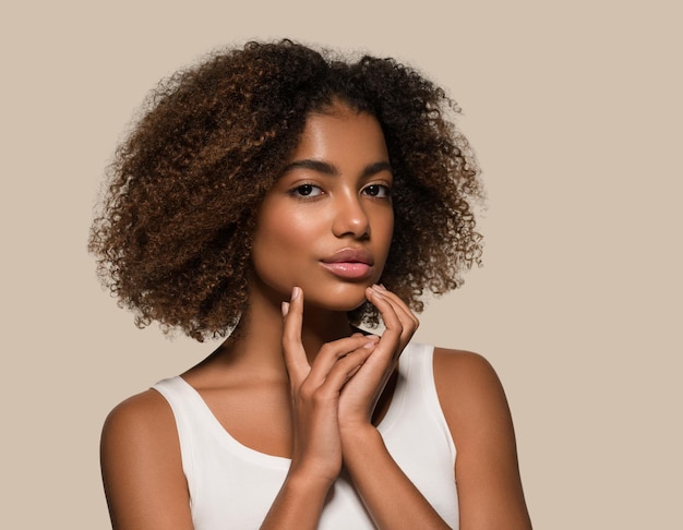 Mooie Afrikaanse vrouw wit t-shirt portret afro kapsel wat betreft haar gezicht Kleur achtergrond bruin