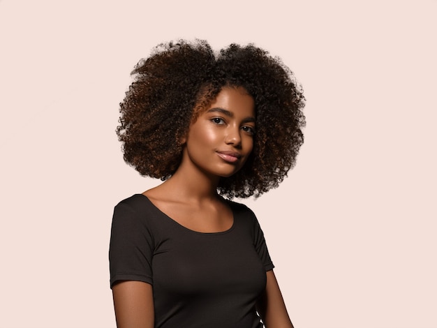 Mooie Afrikaanse vrouw zwart t-shirt portret afro kapsel Kleur achtergrond. roze
