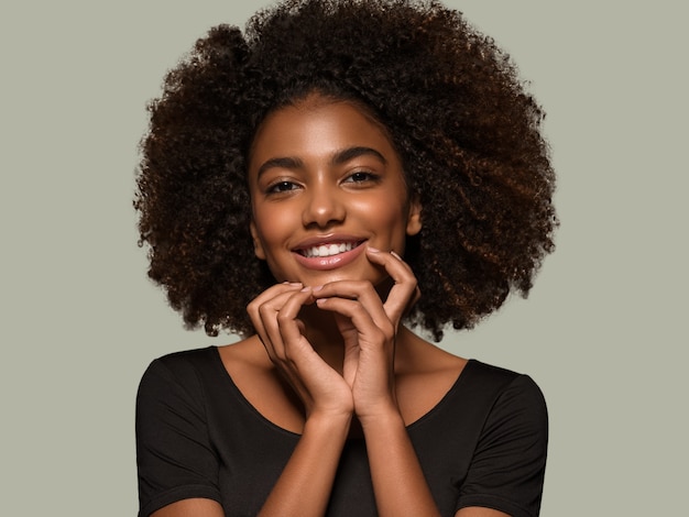 Mooie Afrikaanse vrouw zwart t-shirt portret afro kapsel wat betreft haar gezicht Kleur achtergrond groen