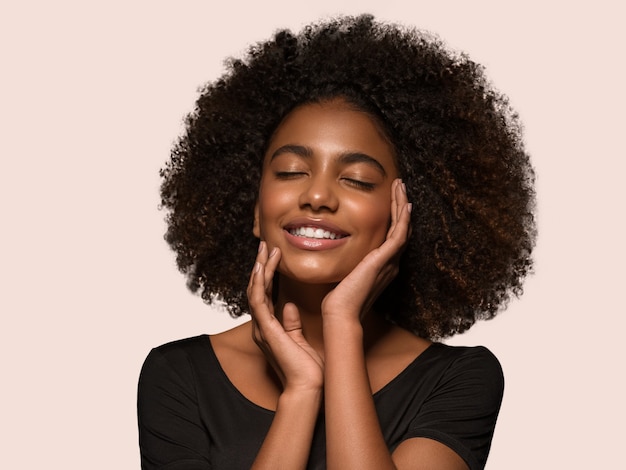 Mooie Afrikaanse vrouw zwart t-shirt portret afro kapsel wat betreft haar gezicht Kleur achtergrond roze