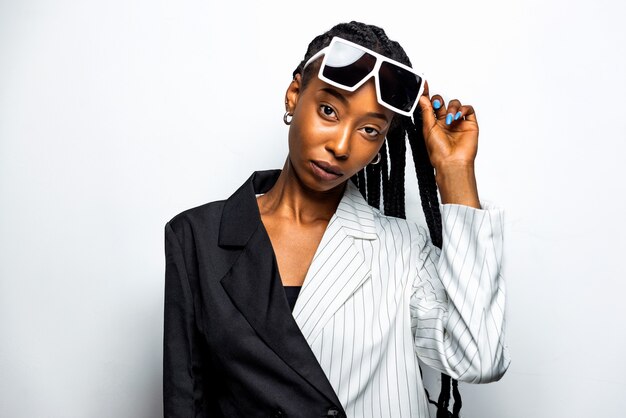 Mooie Afro-Amerikaanse vrouw met afro-vlechten kapsel en stijlvolle kleding - Portret van een jong zwart meisje in studio