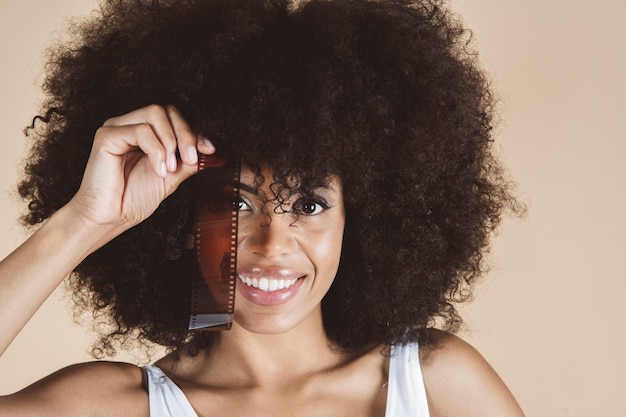 Mooie afro-amerikaanse vrouw met fotofilm, negatief, modefotografie