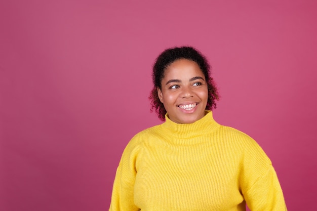 Mooie Afro-Amerikaanse vrouw op roze muur gelukkig lachend vrolijk positief