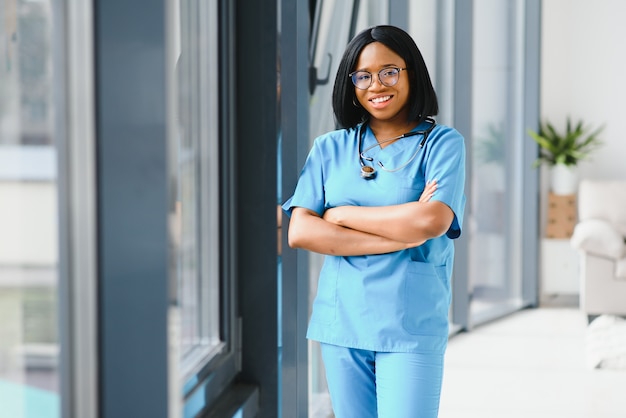 Mooie Afro-Amerikaanse vrouwelijke pediatrische verpleegster in modern kantoor