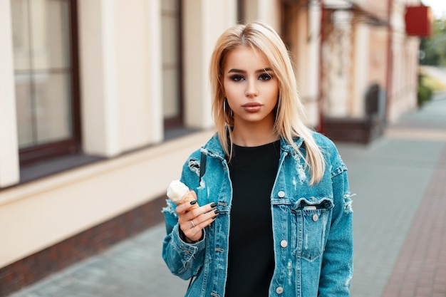 Mooie Amerikaanse vrouw in vintage denim kleding met ijs op zonnige zomerdag