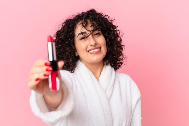 Mooie Arabische vrouw die een badjas en een lippenstift draagt