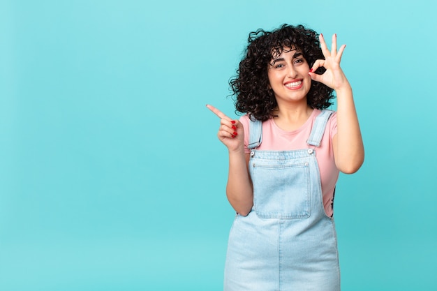 Mooie Arabische vrouw die zich gelukkig voelt, goedkeuring toont met een goed gebaar