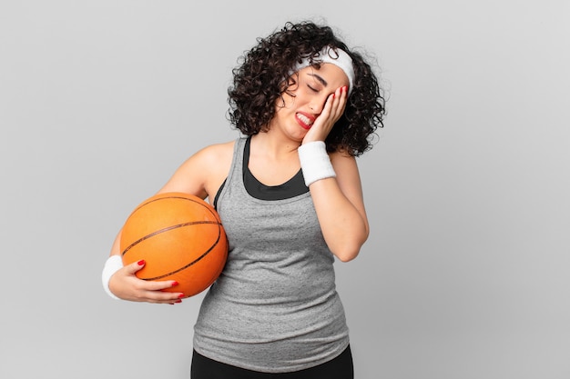 Mooie arabische vrouw die zich verveeld, gefrustreerd en slaperig voelt na een vermoeiende en vasthoudende basketbalbal. sport concept