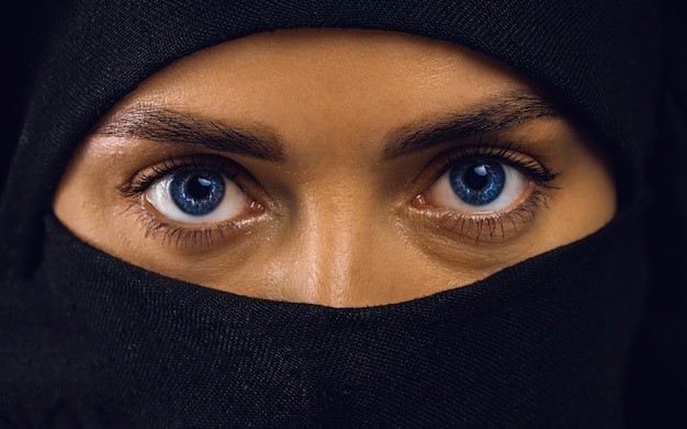 Mooie arabische vrouw in hijab met lichte make-up en blauwe ogen