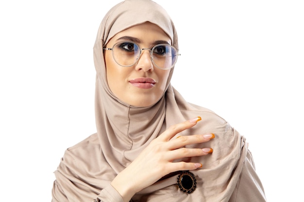 Mooie Arabische vrouw poseren in stijlvolle hijab geïsoleerd op studio achtergrond mode concept