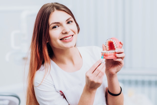 Mooie arts orthodontist laat je zien hoe je voor je tanden moet zorgen