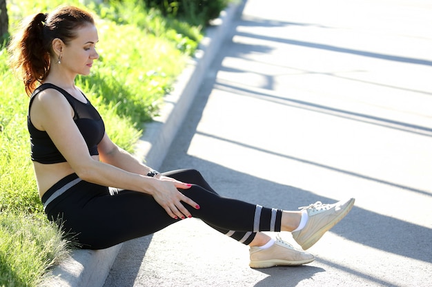 Mooie atletische vrouw die zich vasthoudt aan de knie na een blessure