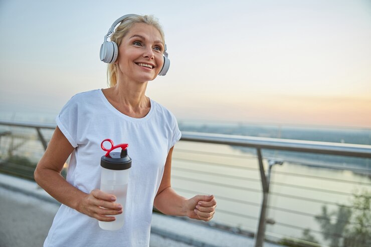 Foto mooie atletische vrouw van middelbare leeftijd met een gelukkige glimlach die 's avonds op een voetgangersbrug loopt