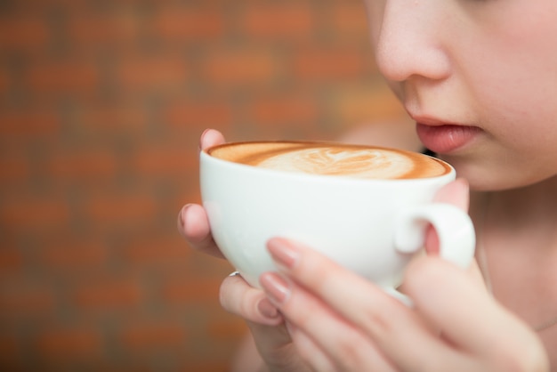 Mooie Aziatische gril het drinken koffie in koffierestaurant