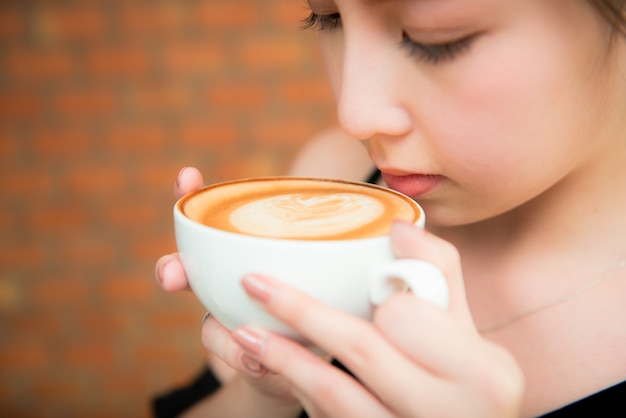 Mooie Aziatische gril het drinken koffie in koffierestaurant