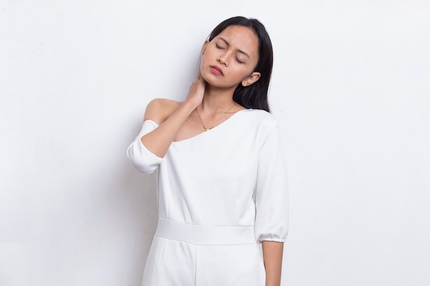 Mooie Aziatische jonge vrouw met keelpijn nek- en schouderpijn geïsoleerd op een witte achtergrond