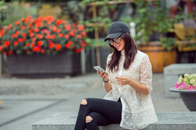 Mooie Aziatische jonge vrouw portret met behulp van smartphone in de stad